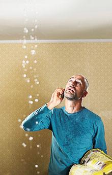 Homeowner examines a ceiling leak while waiting for our plumbers in Los Gatos to arrive.